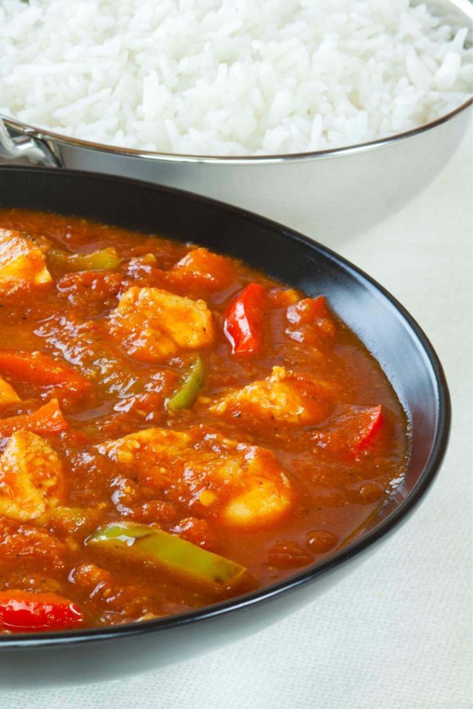Chicken jalfrezi in a bowl with rice and coriander on top.