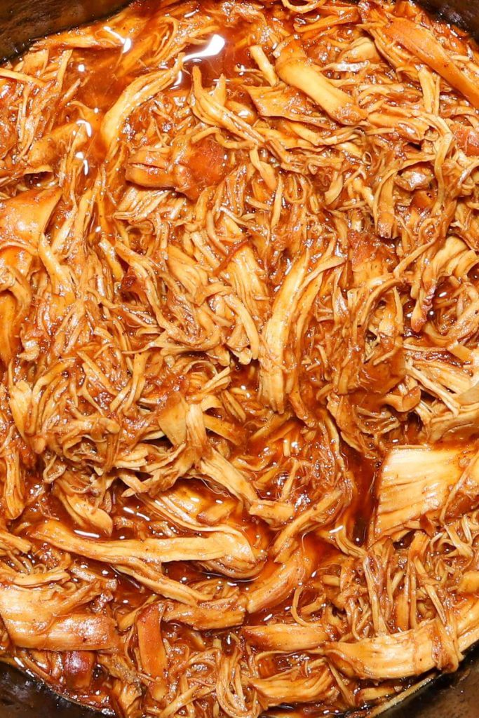 Shredded chicken in a rich sauce cooked in a slow cooker.