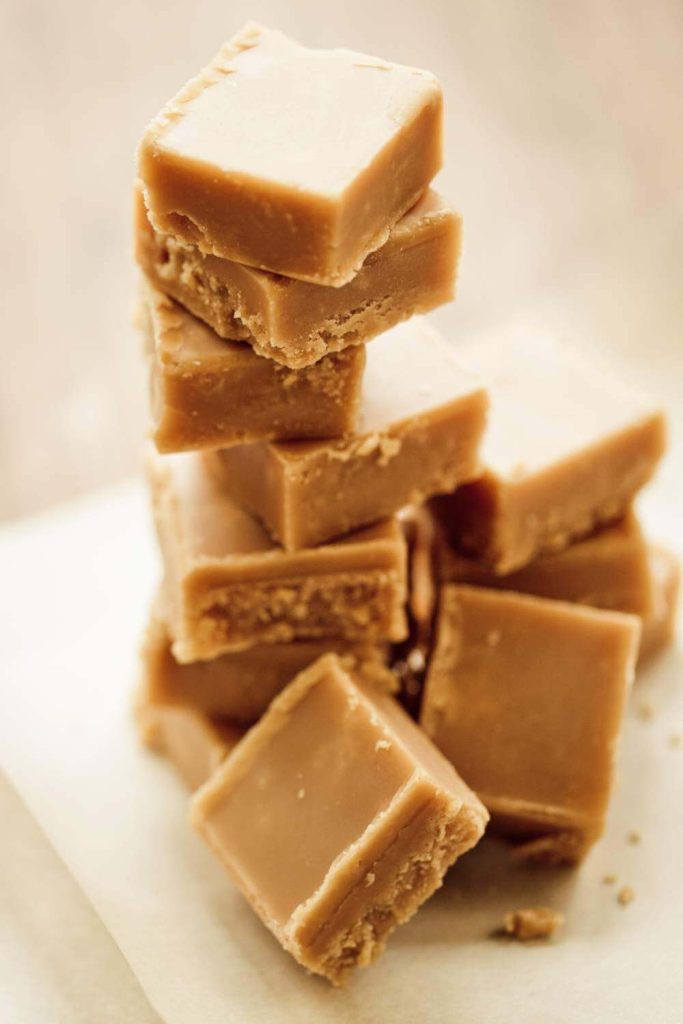 A tower of vanilla fudge blocks with a bite taken out of the top piece.