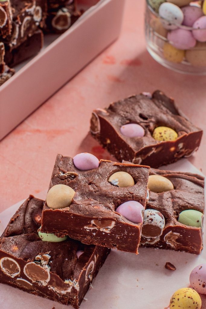 Slow Cooker Mini Egg Fudge with colorful mini eggs in a pink box.
