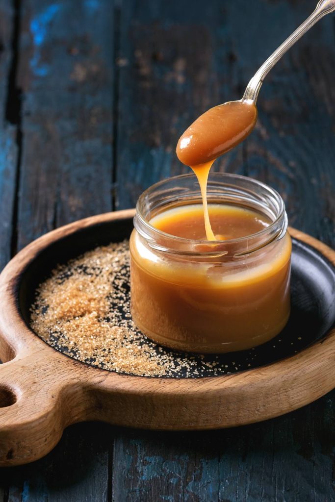  Spoon drizzling caramel sauce.