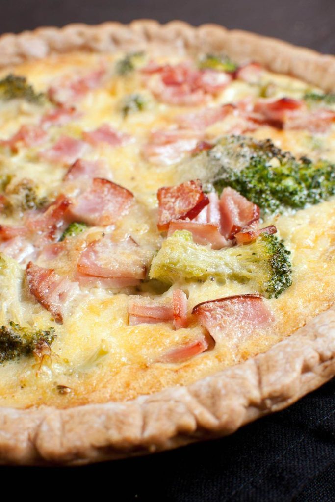 Close-up of a freshly baked breakfast quiche with broccoli and bacon in a slow cooker.