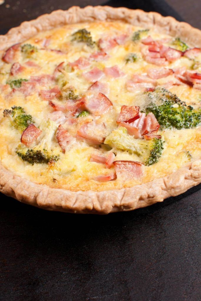 Golden-brown breakfast quiche filled with broccoli and bacon, cooked in a slow cooker.