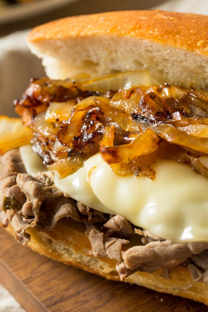 Beef sandwich with melted cheese and caramelized onions.