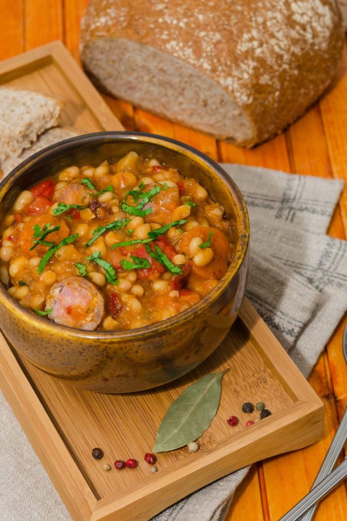 Hearty slow cooker sausage cassoulet in a bowl, ready to be served with a side of bread.