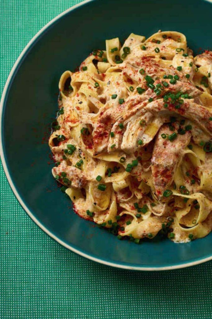 A plate with garlic chicken and pasta from a slow cooker.