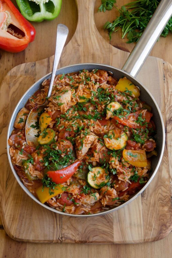 Hearty slow cooker chicken and chorizo jambalaya in a pan, garnished with parsley.