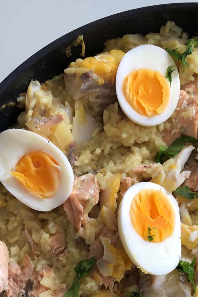  Close-up of slow cooker kedgeree with eggs and fresh herbs, emphasizing the dish's creaminess.