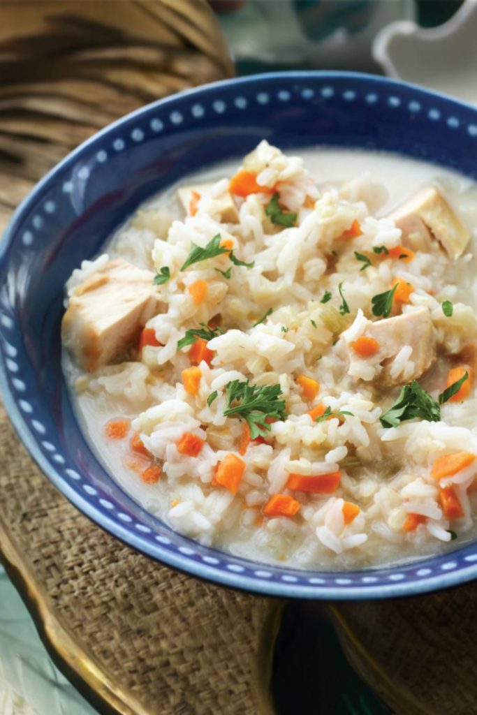 A close-up of comforting chicken rice soup with vegetables, seasoned to perfection.