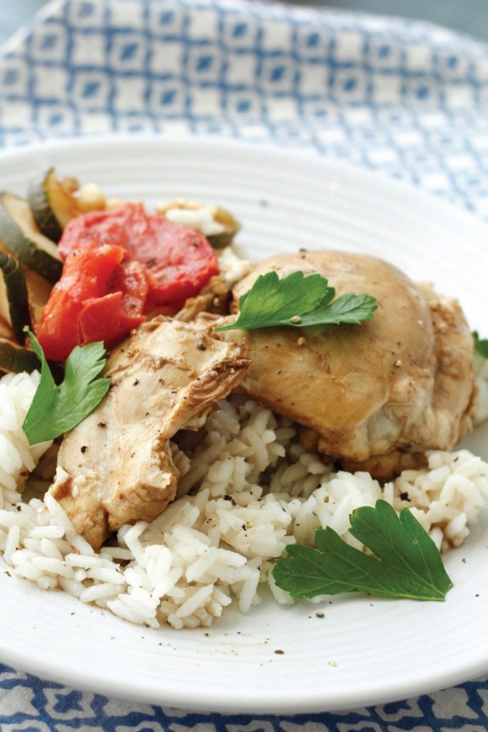 A plated serving of Spanish chicken with vegetables and rice, ready to be savored.