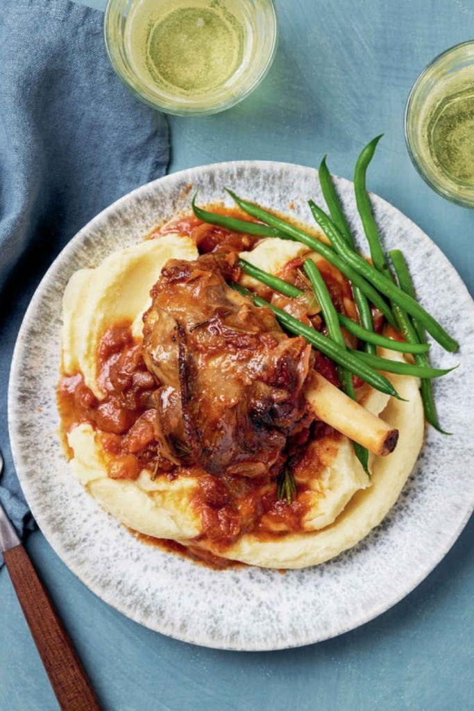 Slow cooked lamb shanks with orange marmalade glaze, served with potatoes and green beans.