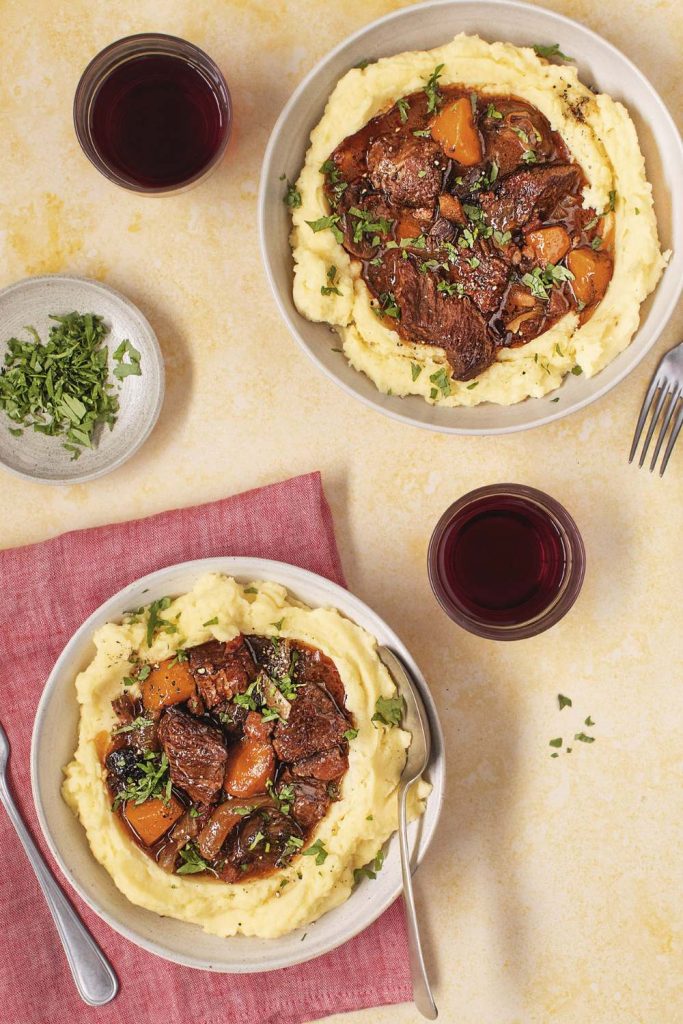Slow Cooker Beef Bourguignon served over mashed potatoes.