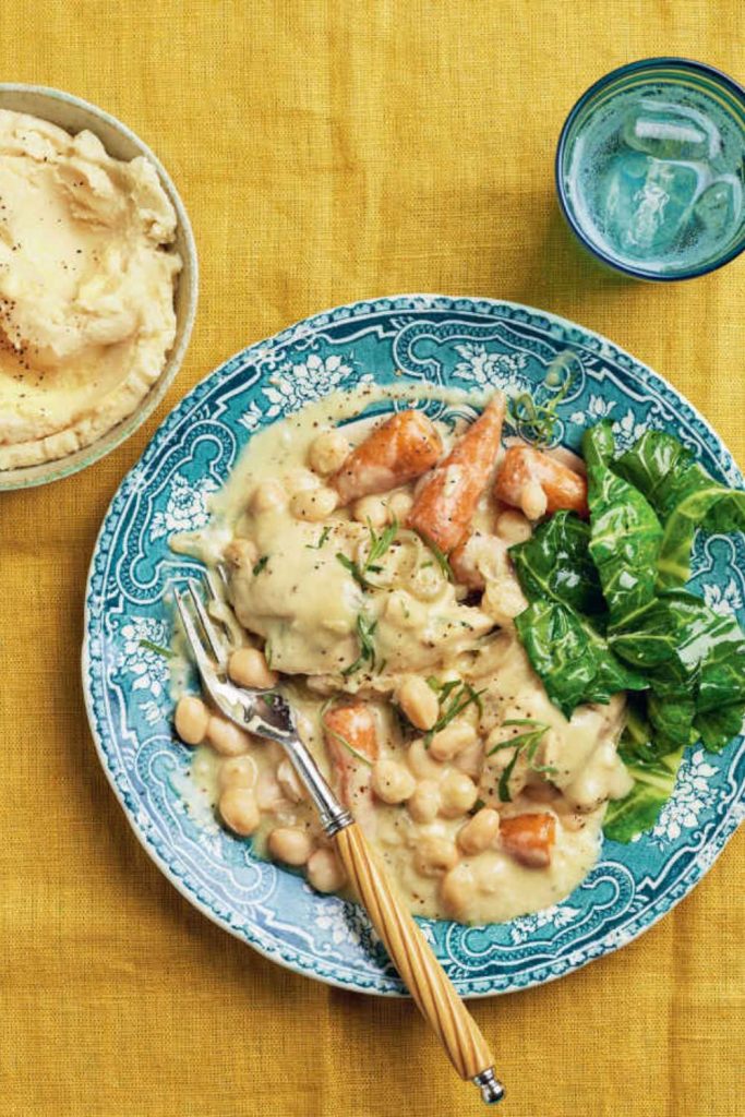 Slow Cooker Tarragon Chicken with creamy sauce, chickpeas, and spinach on a patterned plate.