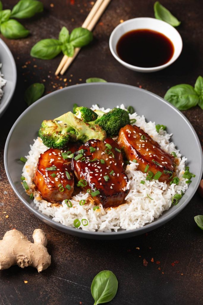 Slow cooker pork belly with rice and broccoli on a plate.