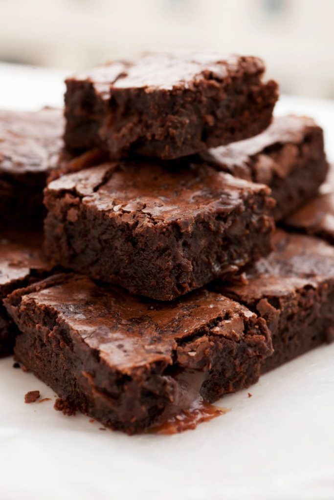 Stack of moist slow cooker brownies on a plate.