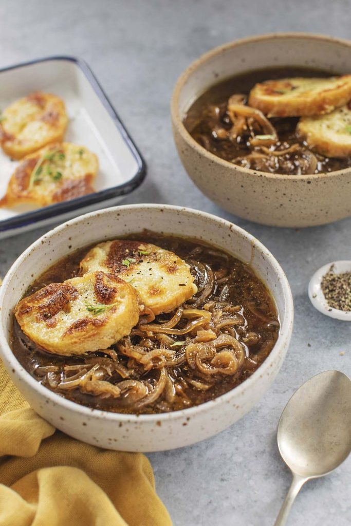 A bowl of Slow Cooker French Onion Soup with toast on top.