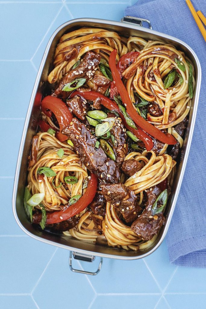Tasty honey chilli beef noodles with vegetables in a meal prep container.