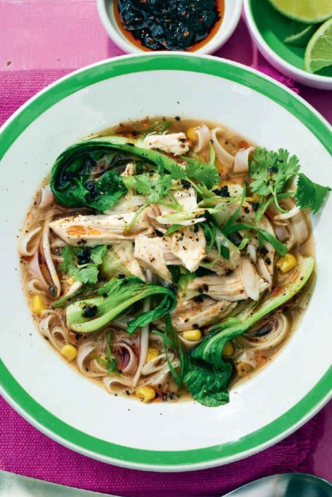 Slow Cooker Chicken Noodle Soup with bok choy and cilantro in a green-rimmed bowl.