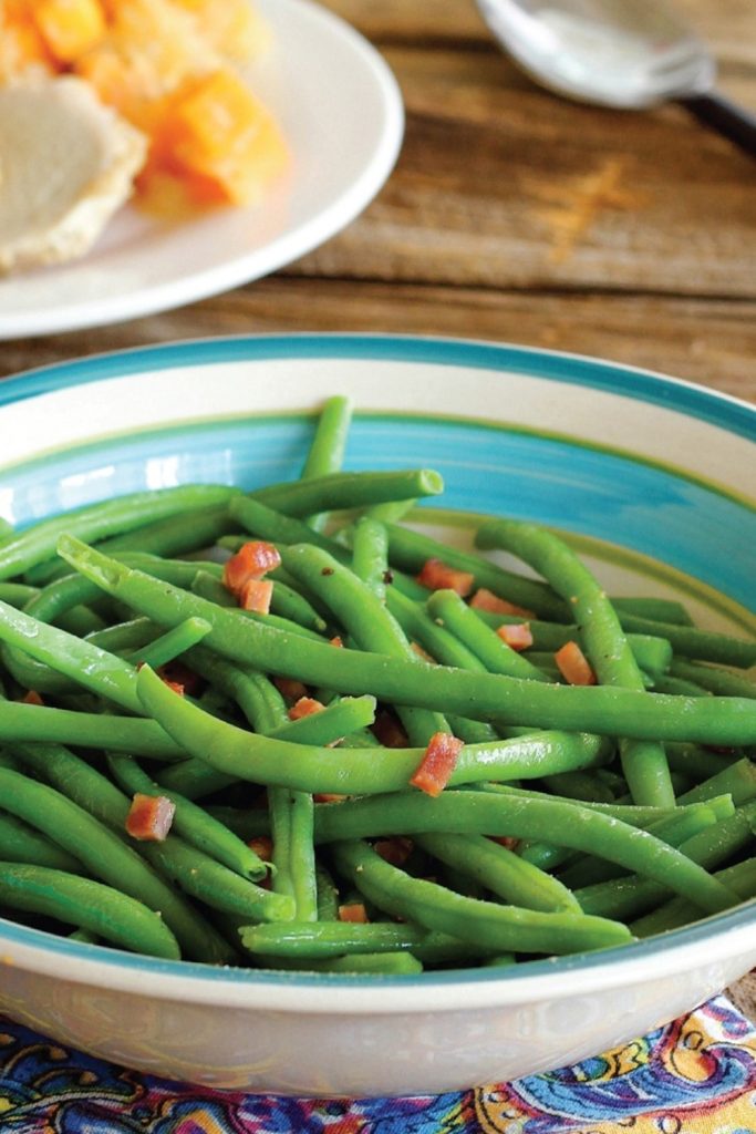 seasoned slow cooker green beans with bacon in a serving bowl.
