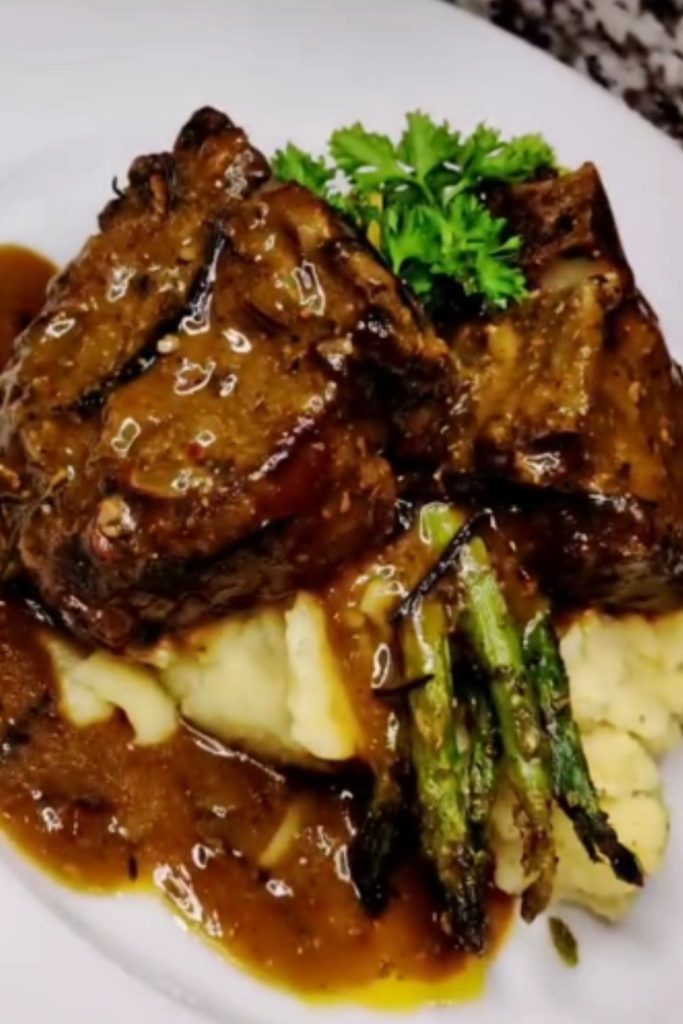 Plated Slow Cooker French Onion Lamb Chops with asparagus and mashed potatoes.