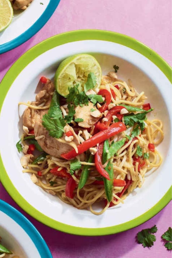  Slow Cooker Chicken Pad Thai with noodles, red bell peppers, snap peas, cilantro, and lime.