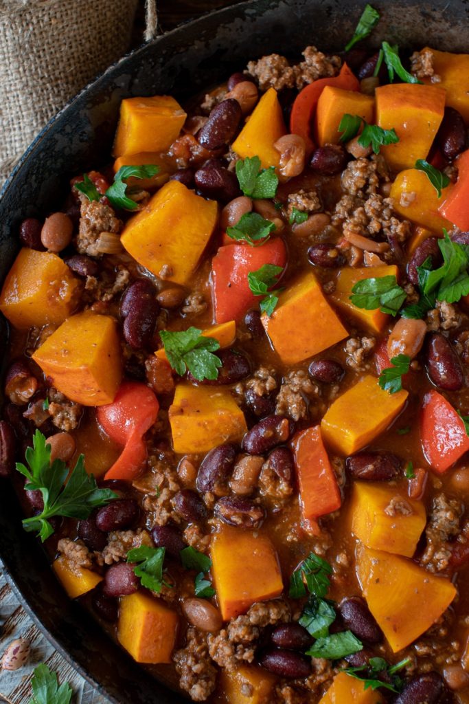 Slow Cooker Savoury Mince with vegetables and beans in a cast iron skillet.