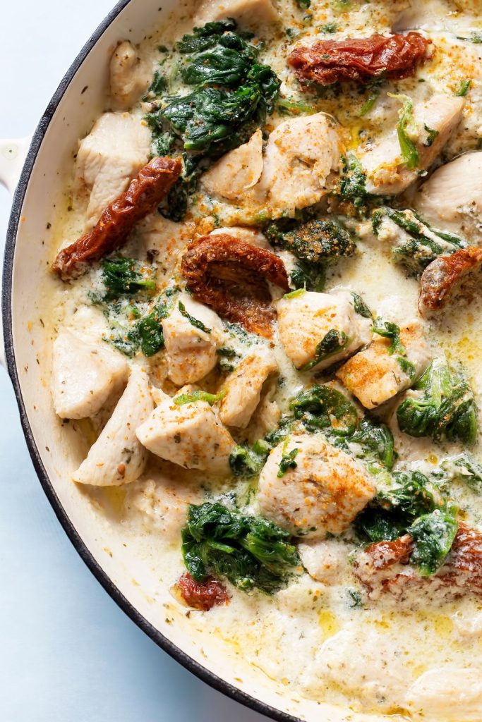 Slow Cooker Chicken Heaven with creamy sauce, spinach, and sun-dried tomatoes.
