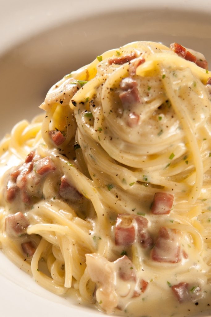 Slow Cooker Chicken Boscaiola with creamy sauce and pancetta on spaghetti.