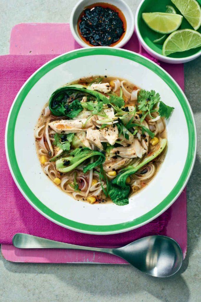 Slow Cooker Chicken Noodle Soup with bok choy, noodles, and cilantro in a green-rimmed bowl.