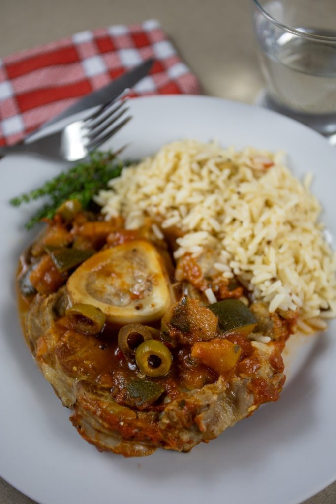  Slow Cooker French Onion Osso Bucco served with rice on a white plate.