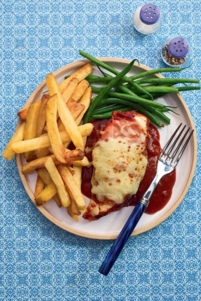 Slow Cooker Hunter’s Chicken with melted cheese, green beans, and fries on a plate.