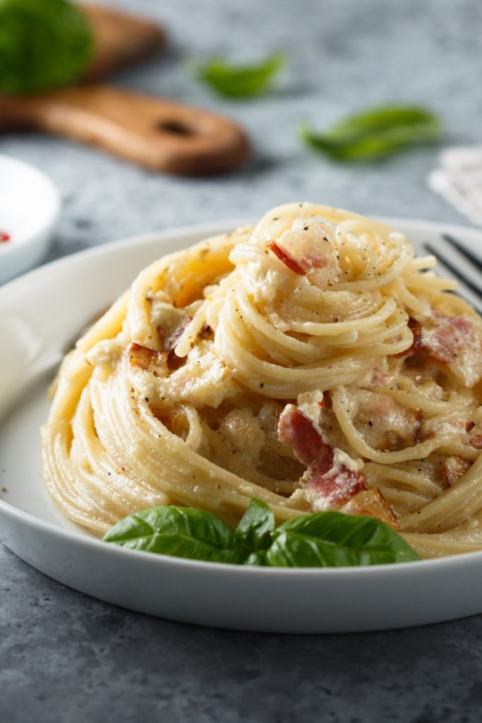 Slow Cooker Pasta Carbonara with crispy bacon on a white plate.