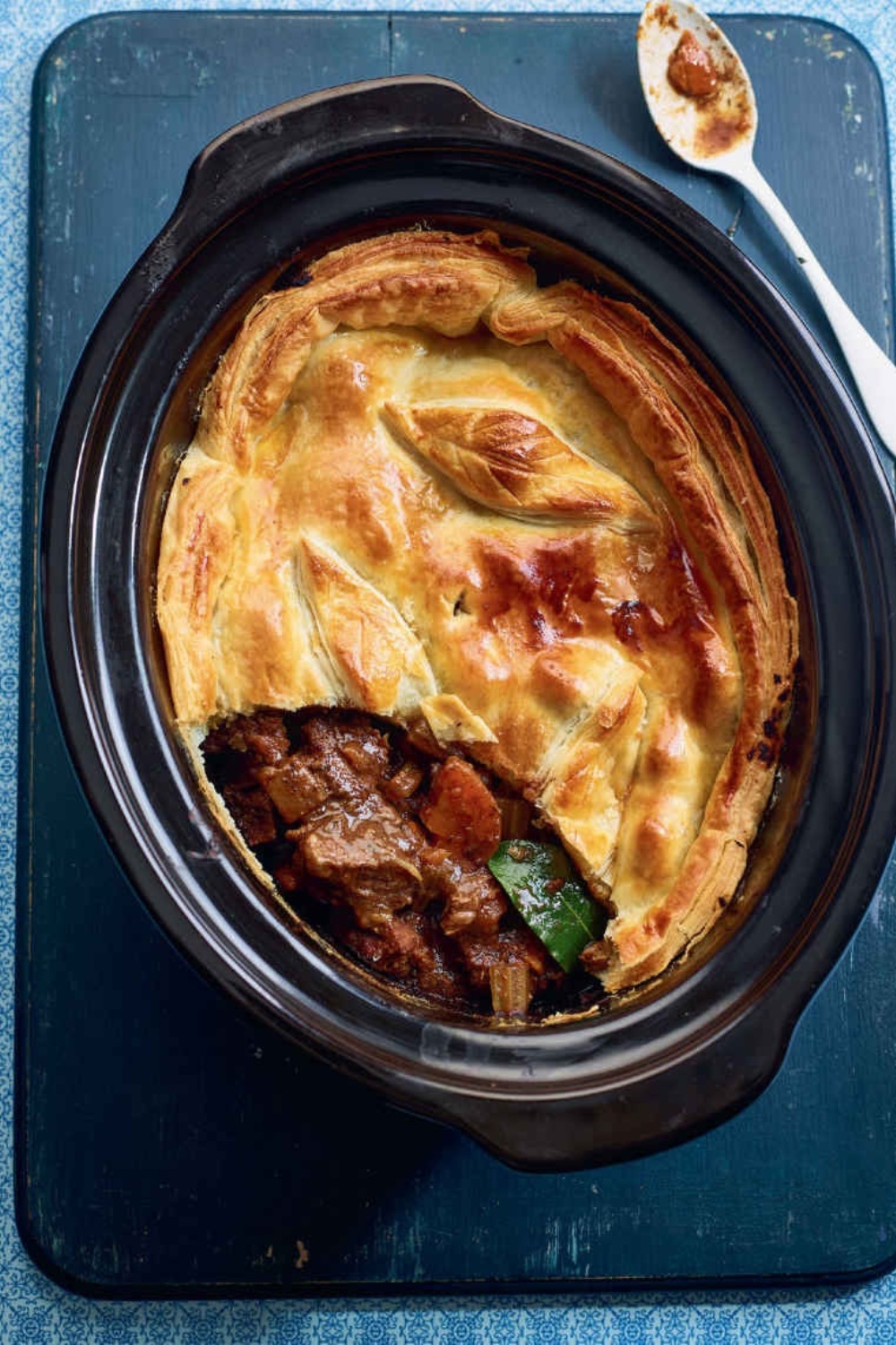 Slow Cooker Steak and Guinness Pie in a crock pot with golden crust.