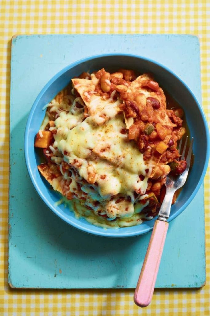 Slow Cooker Vegetarian Enchiladas topped with melted cheese in a blue bowl.
