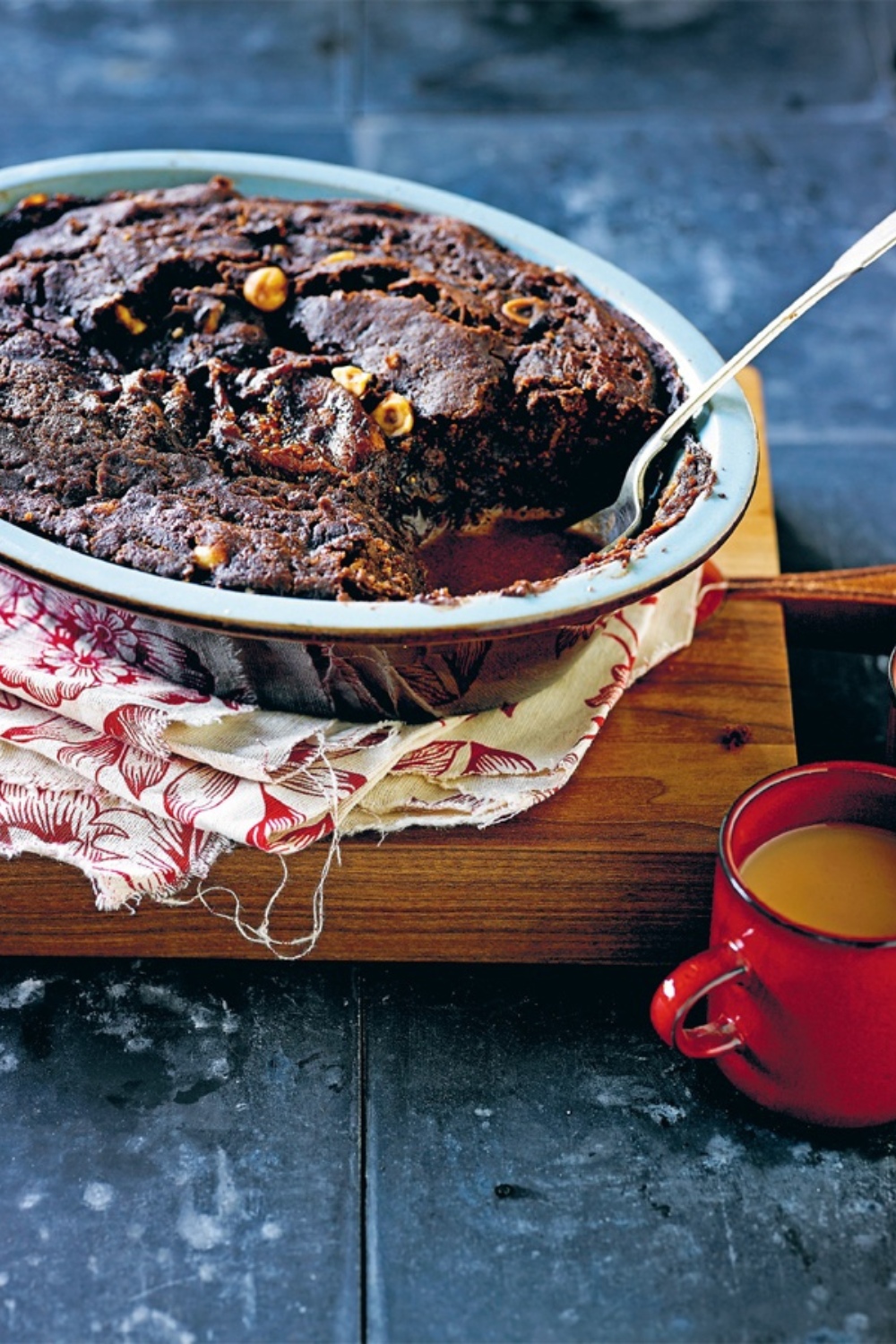 Chocolate Self Saucing Pudding in a slow cooker dish with a red mug of tea.