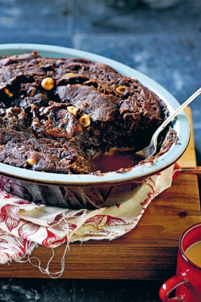 Chocolate Self Saucing Pudding served in a slow cooker dish, with a portion scooped out.