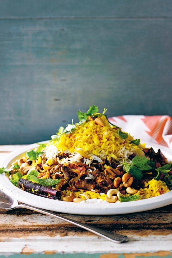 Slow Cooker Lamb Biryani with yellow and white rice, garnished with cilantro and cashews.