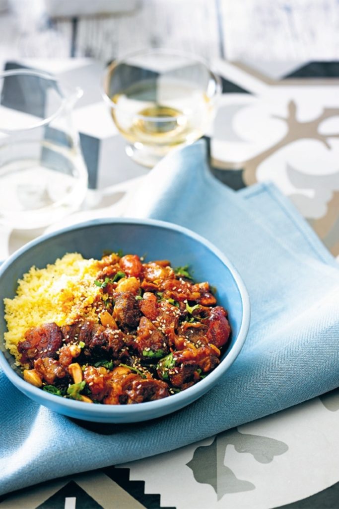 Slow Cooker Lamb Tagine Harissa in a blue bowl with couscous.