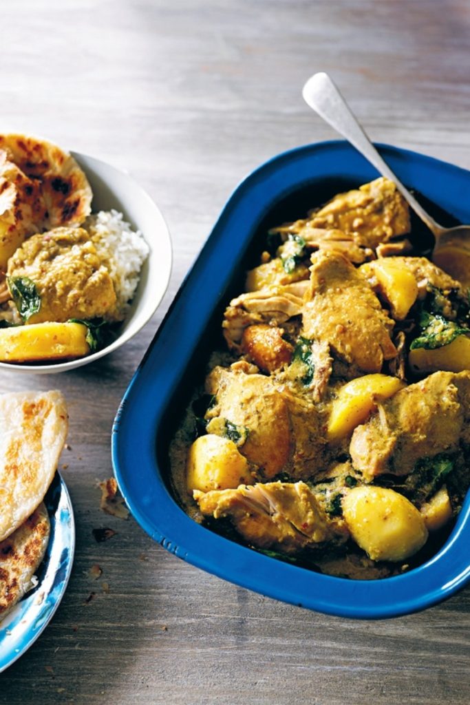 Slow Cooker Malaysian Chicken Curry with potatoes and spinach in a blue dish.