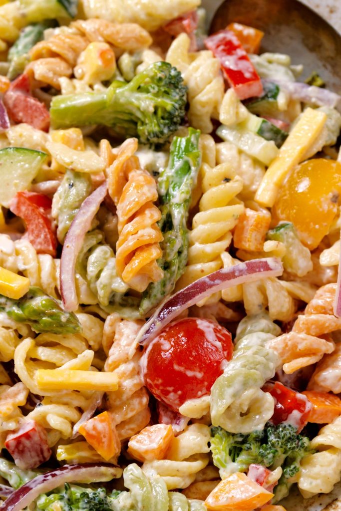 Colorful pasta primavera with vegetables in a creamy sauce.