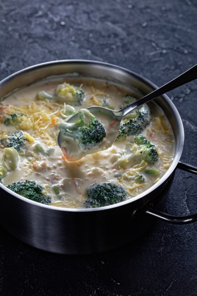 Bowl of 4-ingredient Slow Cooker Broccoli Cheese Soup with melted cheese on top.