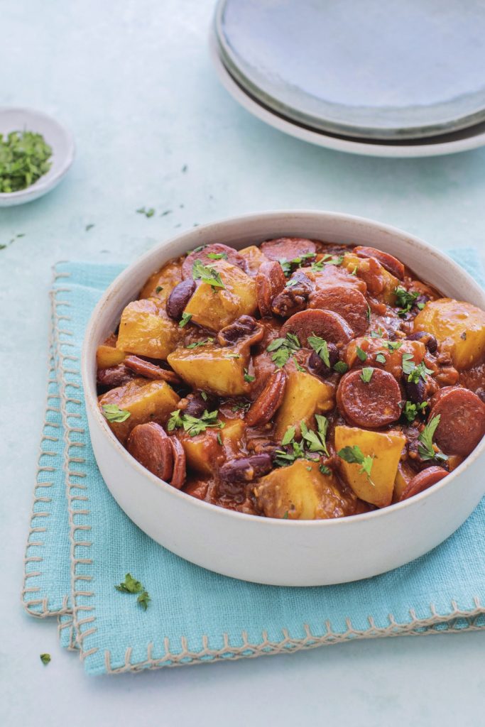 Bowl of chorizo and kidney bean stew with potatoes, garnished with cilantro.
