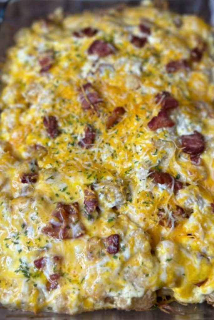 Tater Tot Chicken Casserole in a baking dish with melted cheese and bacon.