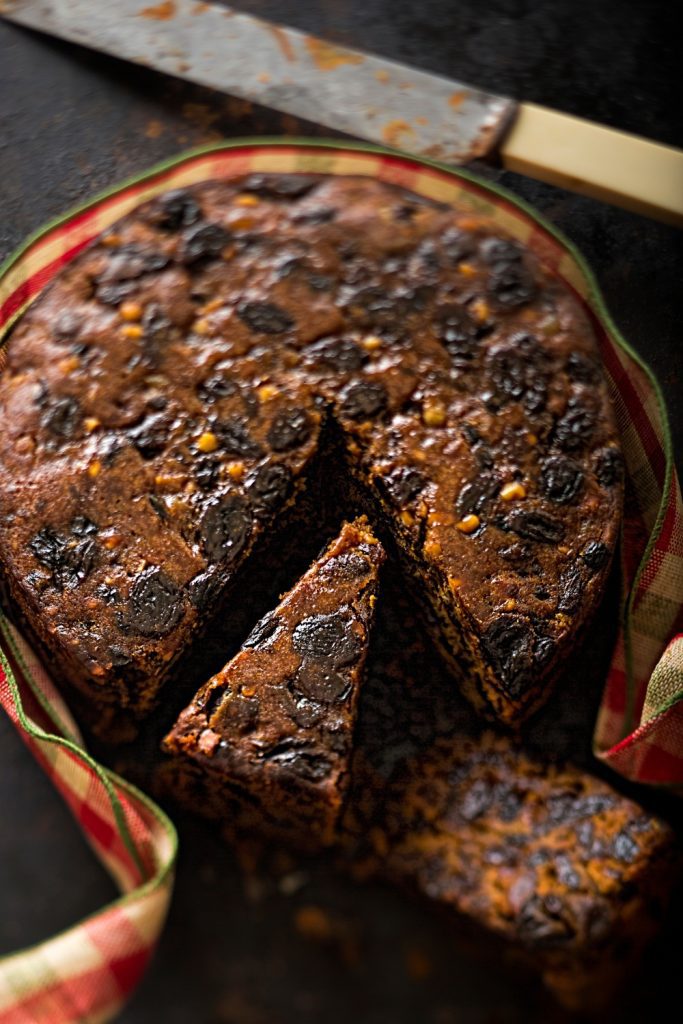 Whole 4-ingredient Slow Cooker Fruit Cake with one slice cut and placed in front.