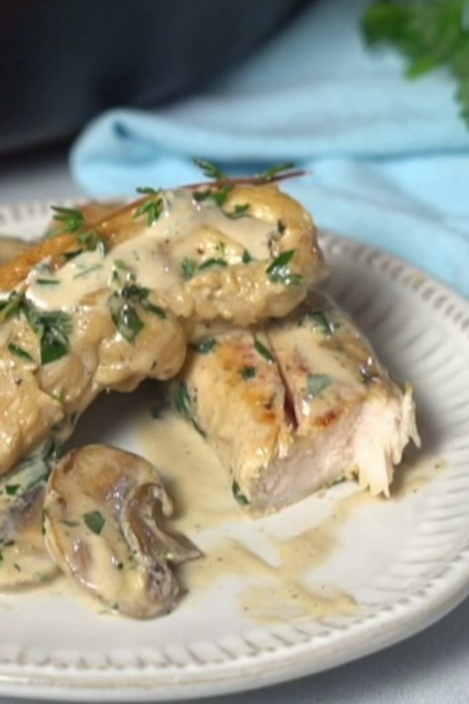  Slow Cooker Chicken Mushroom Casserole served on a plate with creamy sauce and herbs.