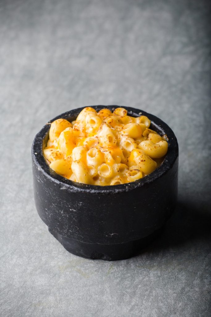 Bowl of creamy mac and cheese with a cheesy crust.