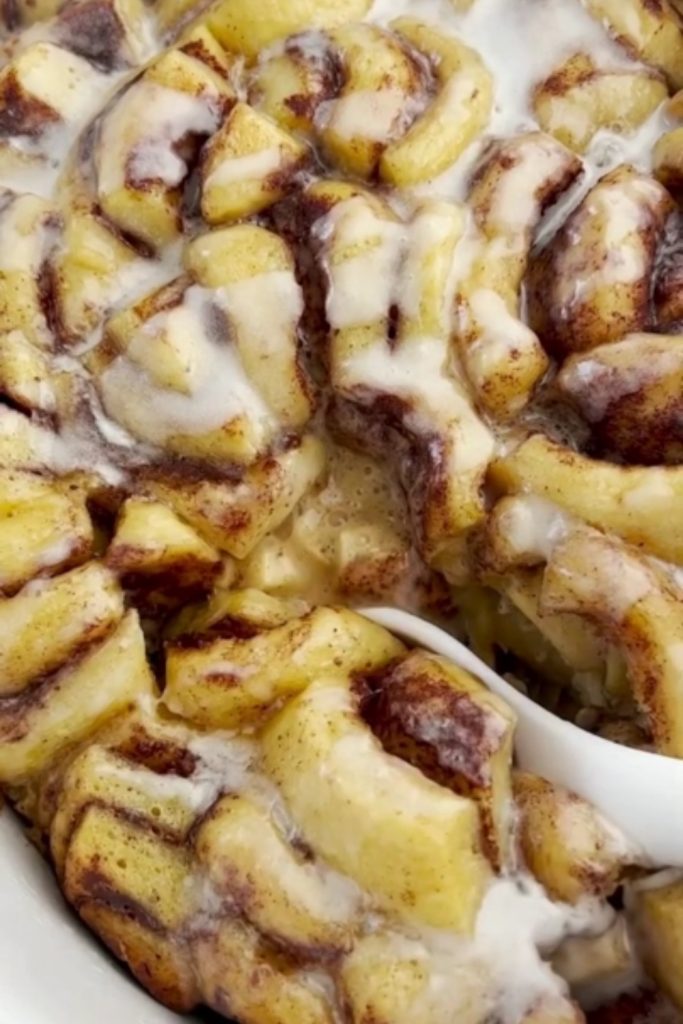 Slow Cooker Cinnamon Roll Casserole with Apples topped with icing.