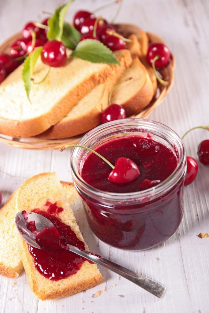 Overhead view of Slow Cooker Cherry Jam in a jar with cherries.