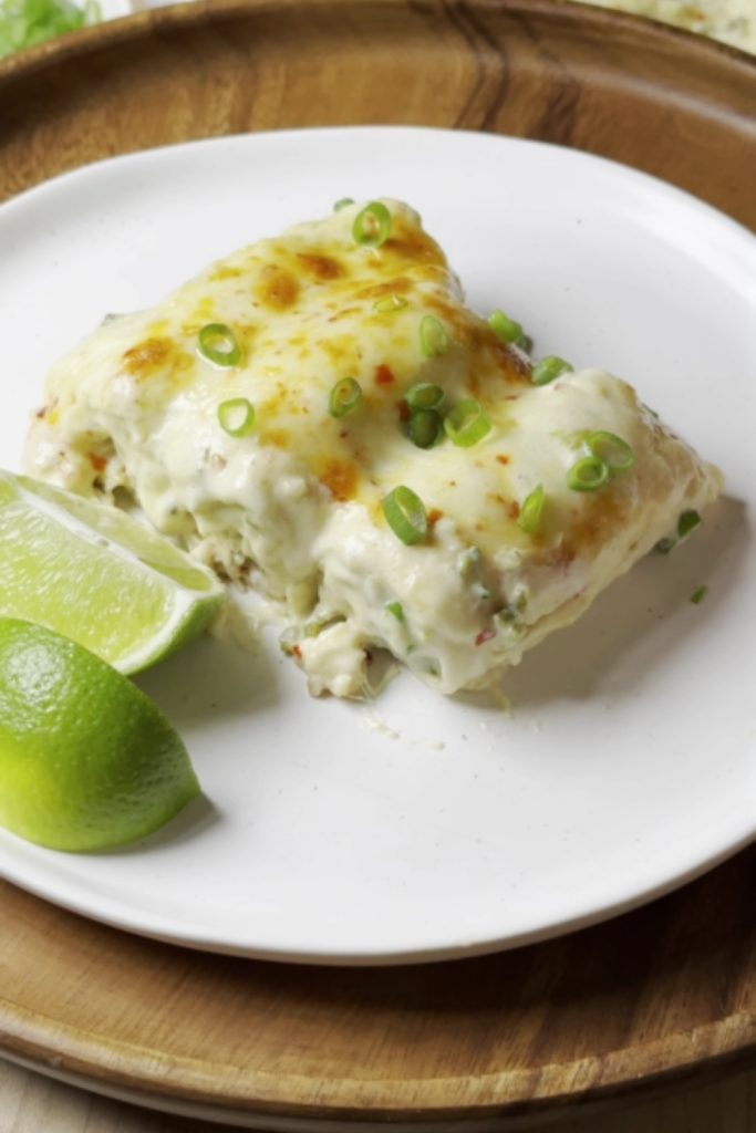 White Chicken Enchilada covered in cheese and green onions, served with lime.