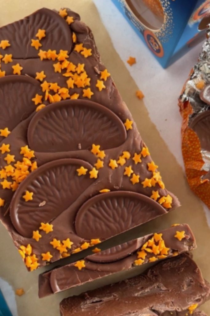 Sliced Slow Cooker Chocolate Orange Fudge with orange chocolate slices and star sprinkles.